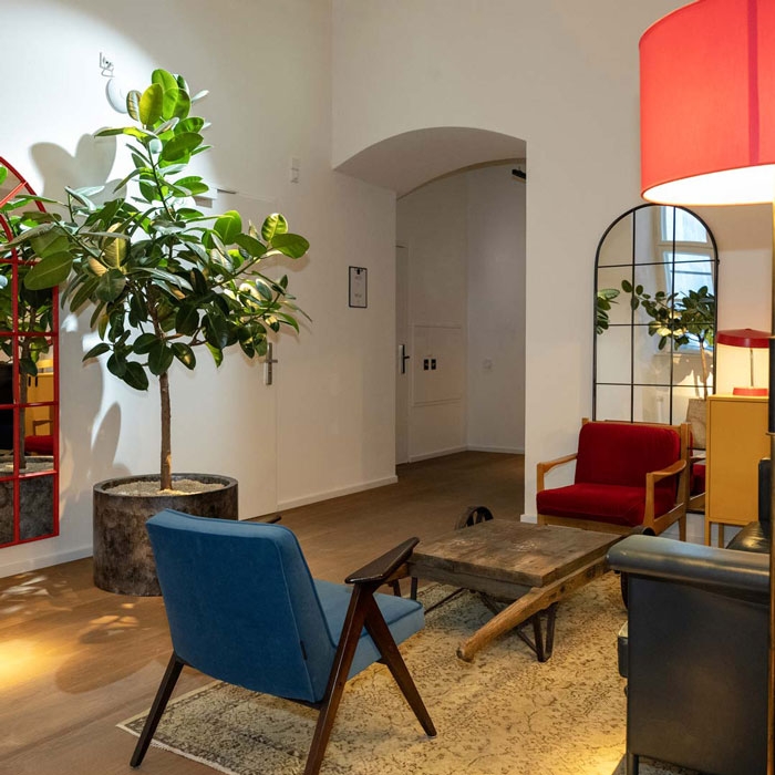 Man sieht einen Sitzbereich in einem Bürogebäude. Die Möbel sind vintage.