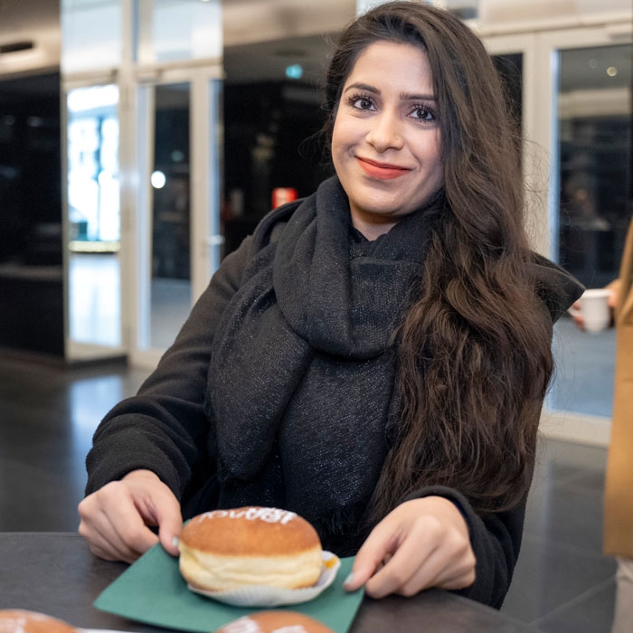 Junge Frau freut sich über den Krapfen